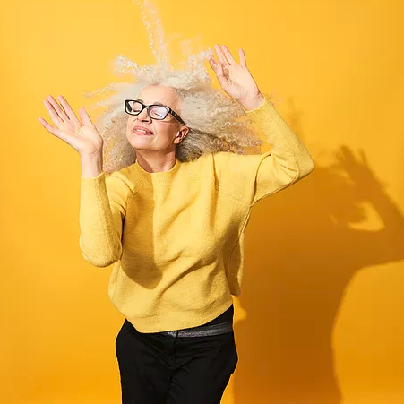 happy senior woman dancing, bright yellow